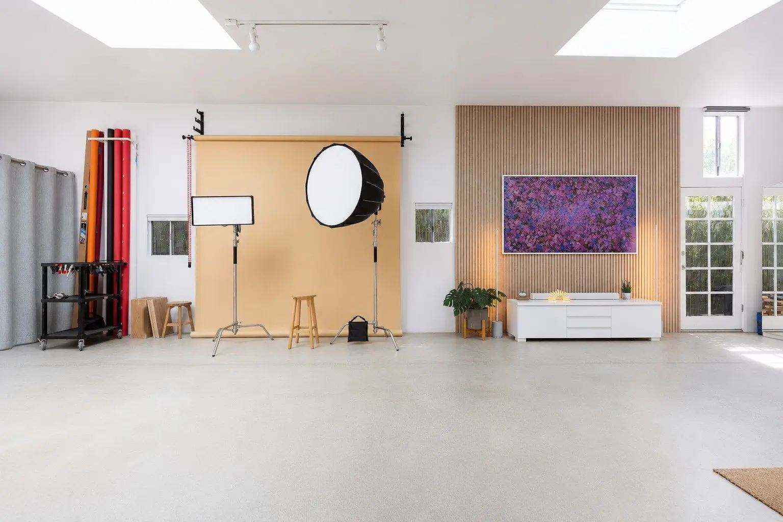 Empty daylight photo studio with a tan backdrop and a softbox
